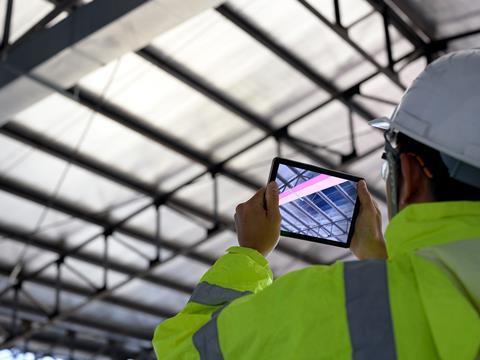 Man consulting a tablet on a building site